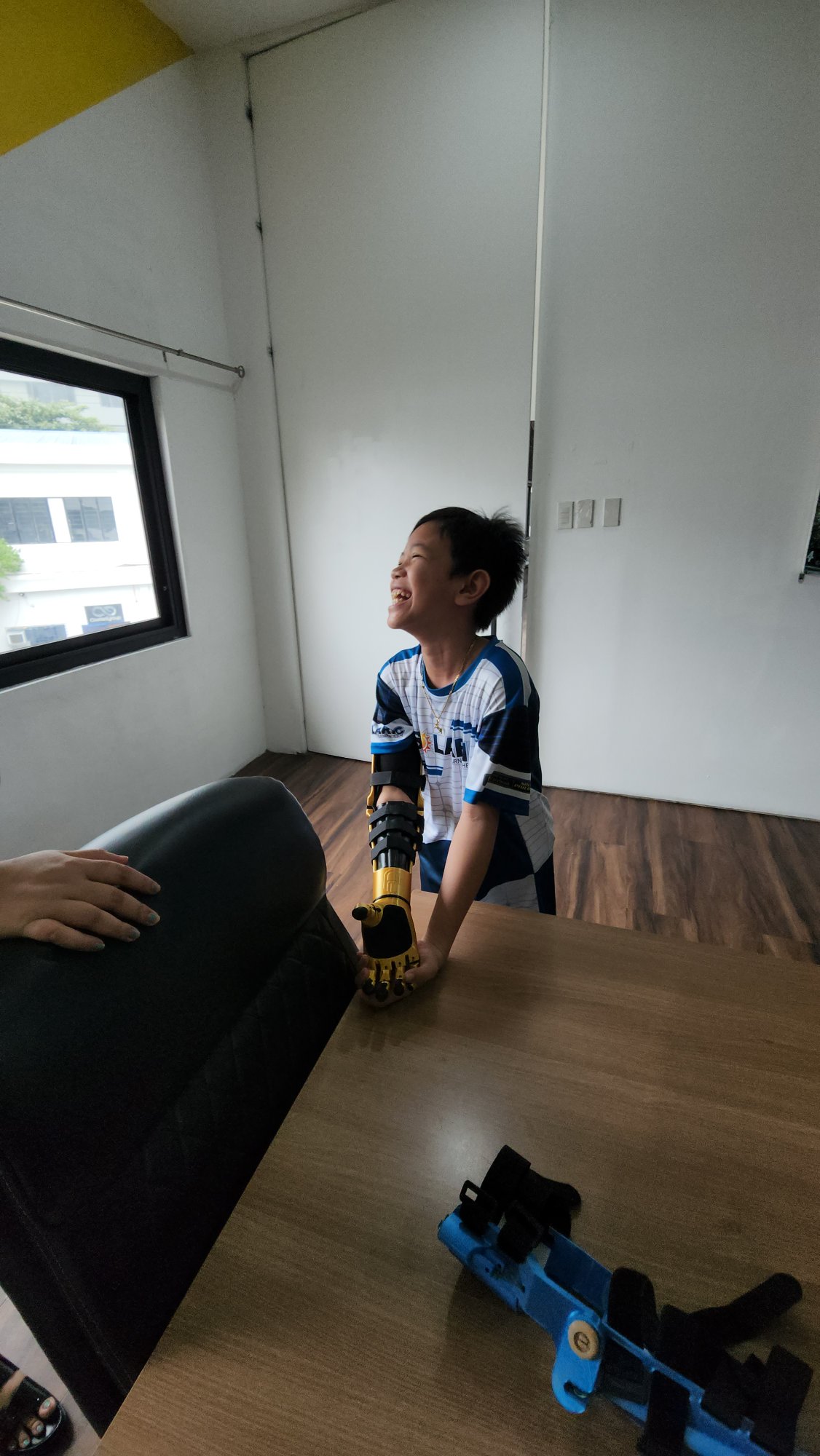 K. laughing at the fitting, gold and blue arms both on the table