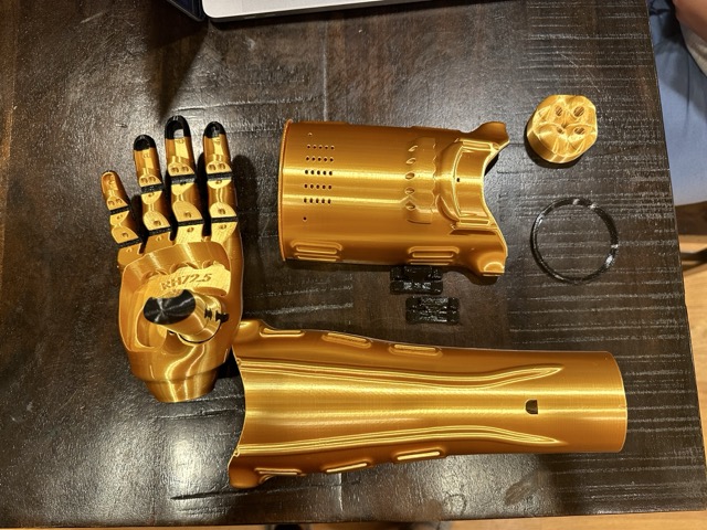 Kinetic Arm components disassembled, hand, forearm shell, and socket laid out