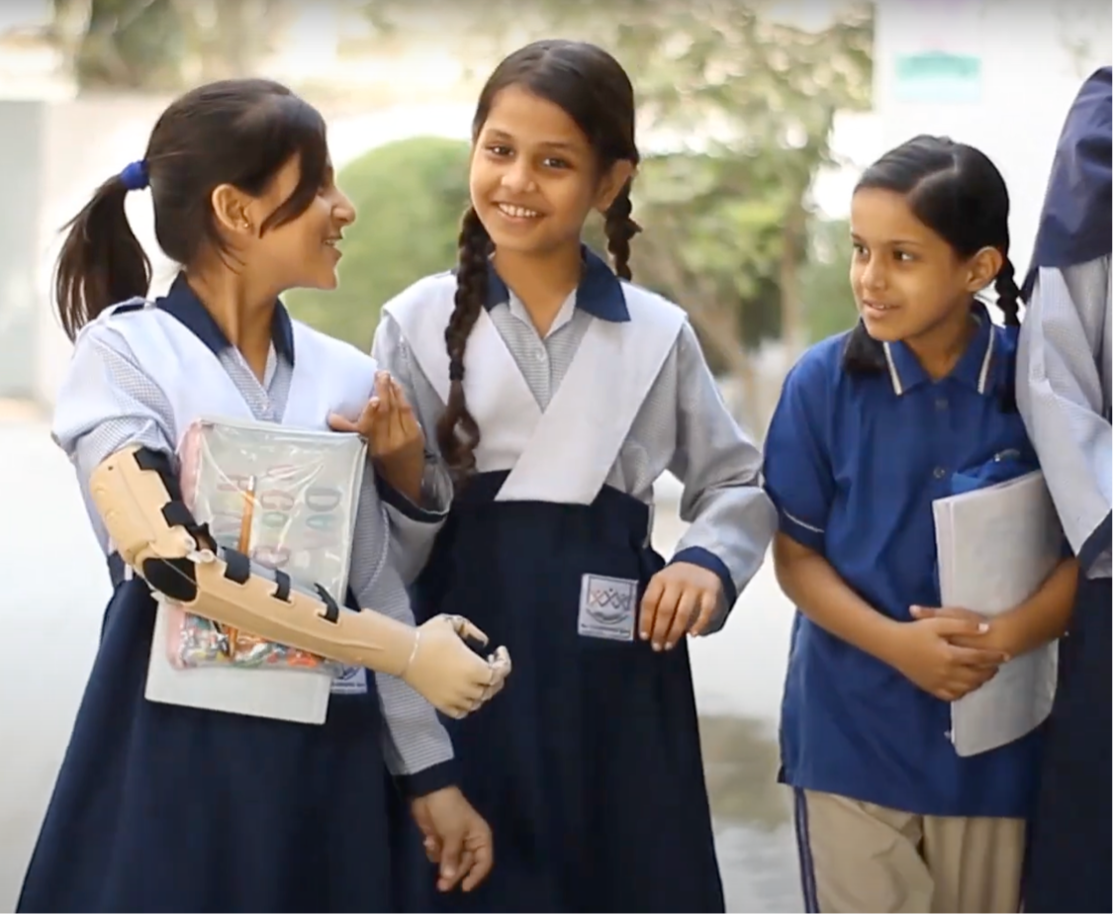 M. walking with friends at school, arm visible