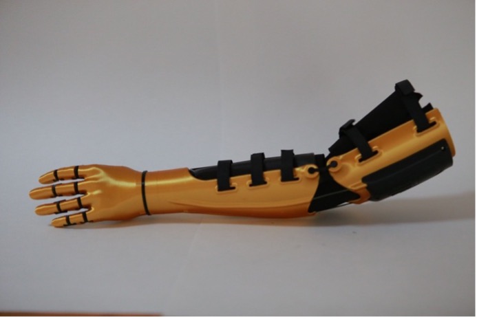 The finished Kinetic Arm, full side profile, gold and black, fingers extended