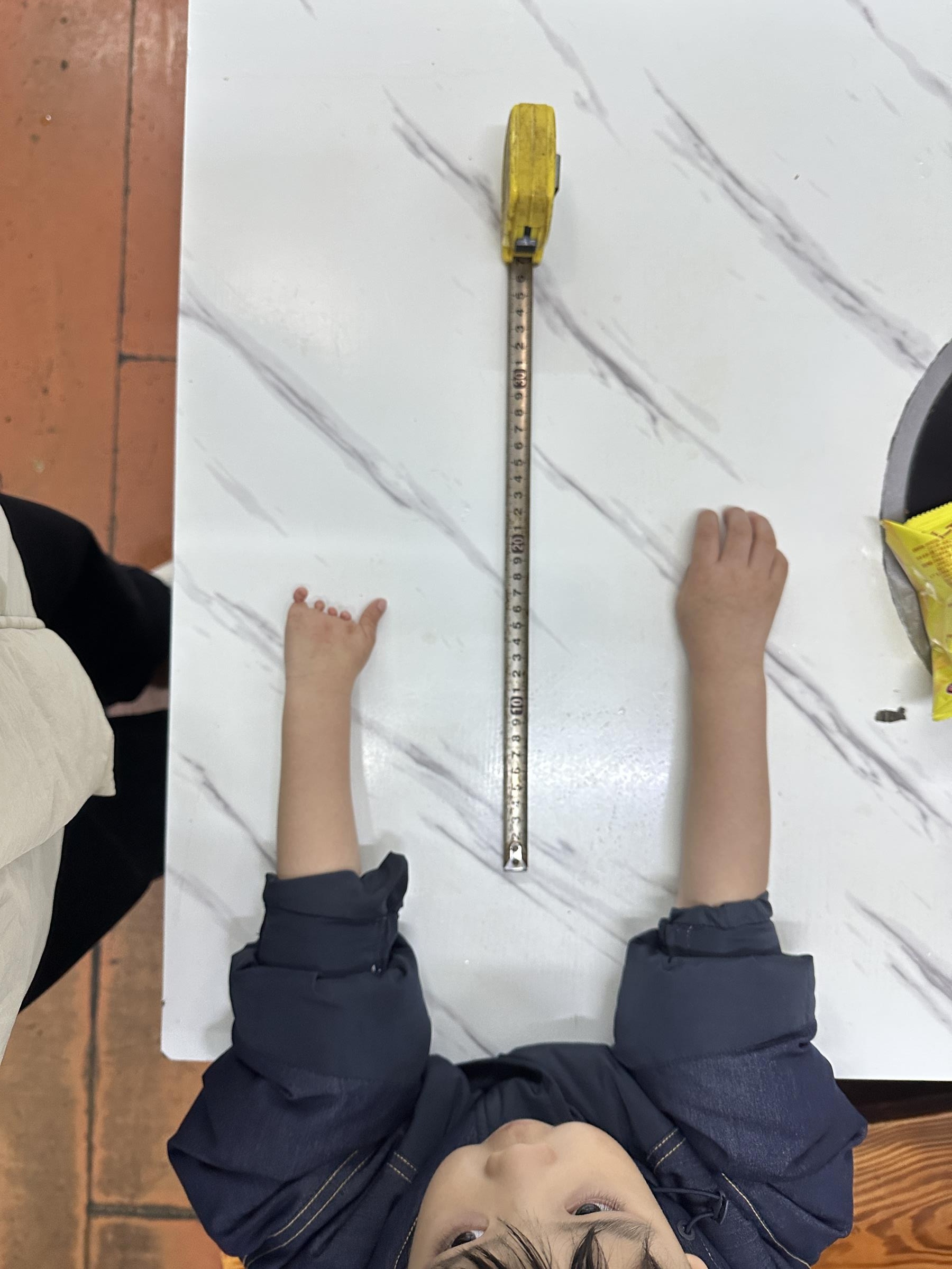 W.'s two arms on a table, measured side by side