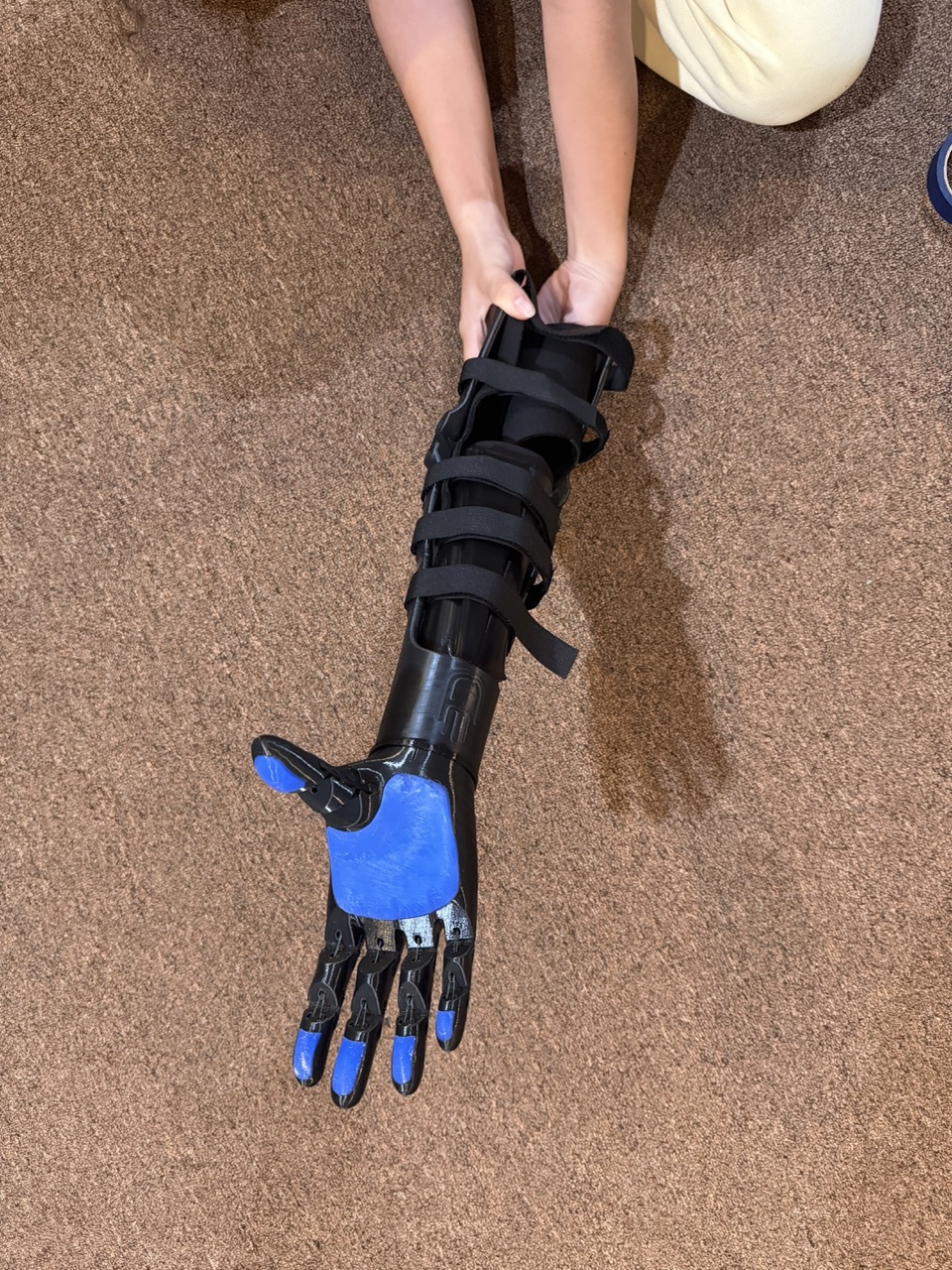 Laila holding the E.F.'s Kinetic Arm, showing the assembled hand and forearm