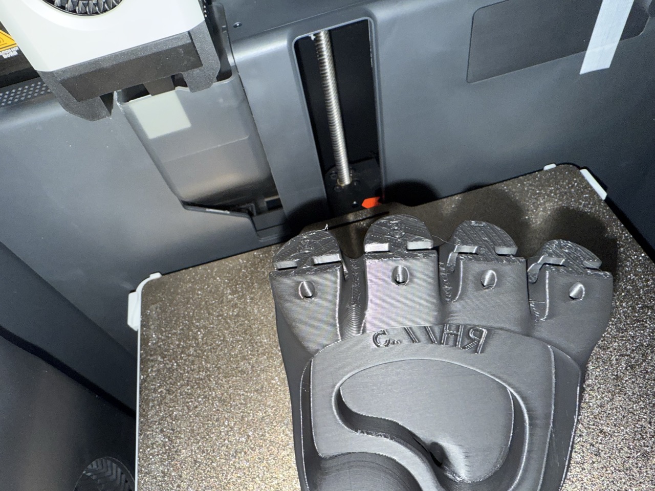 Creality print bed with multiple Kinetic Arm hand components printing simultaneously