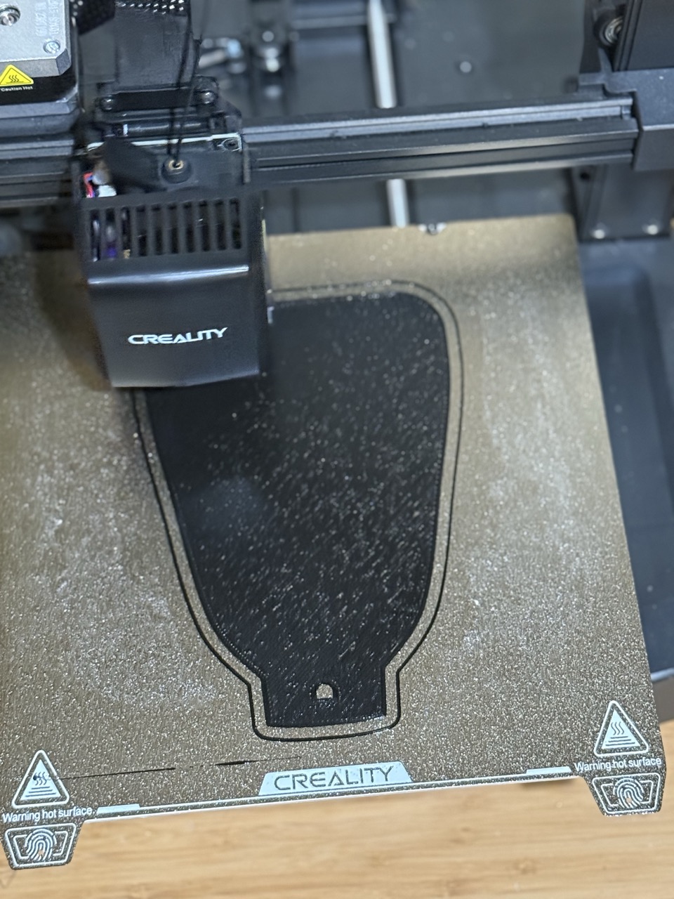 Large palm plate piece printing flat on the Creality print bed, forearm shape visible